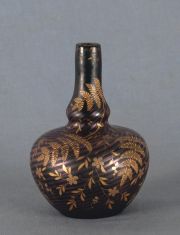 Vaso negro y dorado con decoracin vegetal