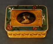Caja rectangular de bronce, tapa con medalln oval con figura de mujer.