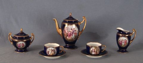 Pzs. de té porcelana azul c/ dorado c/ dec. de personajes, 5 tazas c/pl (1 taza suelta), tetera, azucarera y lechera