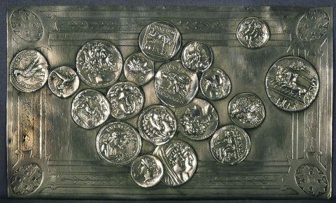 Placa repujada con decoración de monedas en relieve.
