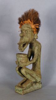 Personaje con cantaro y palo de crin, madera patinada verde.