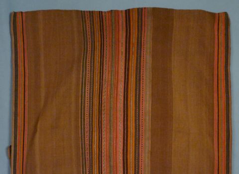 Aguayo, de fondo marrón con listas con guardas geométricas de diferentes colores y motivos.