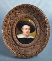 Caballero con sombrero, miniatura en porcelana oval. Marco de madera tallada. Alto total: 10,5 cm.