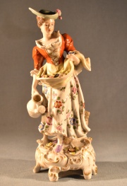 Joven con flores y regadera. Figura de porcelana europea, Marcada J.H. al dorso en azul. Alto 22 cm