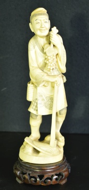 Figura con hazada y frutos de marfil oriental. 25,5 cm.