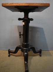 ADJUSTABLE TABLE, pequeña mesa auxiliar con fuste y patas de hierro culminadas en ruedas y con manijas regulables.