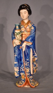 Geisha portando vaso, porcelana oriental policromada. Alto 36,8 cm.