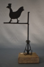 PEQUEÑA VELETA, de metal pintado de negro con figura de gallina. Con base de madera. Alto total: 26 cm.