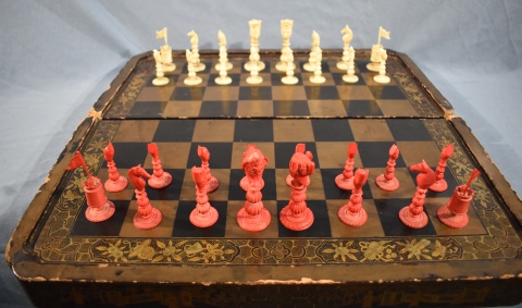 Tablero de ajedrez chino, laqueado negro y dorado, deterioros, con 32 trebejos. Restauraciones. Circa 1880. 49 x 50 cm