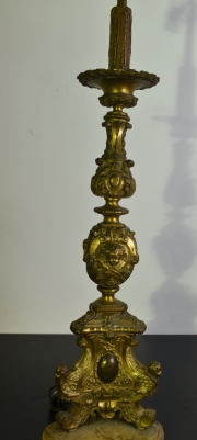 Candelero de bronce ornado con angelitos y roleos. Faltantes, tranformado en lámpara 2 luces. Alto total 93 cm.