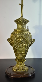 Vaso de bronce, transformado en lámpara, con base de madera, 2 luces. Dec. de cabezas de ángeles. 83 cm
