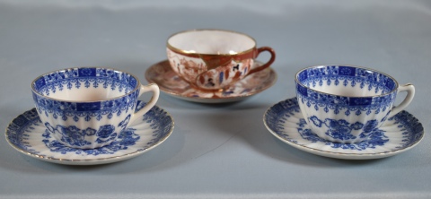 Tres tazas en porcelana japonesa, dos azules y una bord.