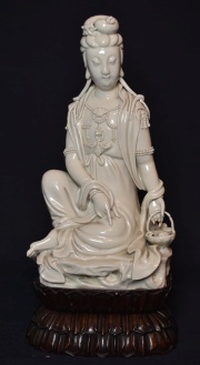 Guan Yin, porcelana Blanc de Chine. Base madera. Peq. desperfectos en dedo y canasta.
