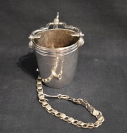 BALDECILLO RIOGRANDENSE, realizado en plata. Estilizado brocal con cariátides de leones. Vaso liso. Cadena con gancho.