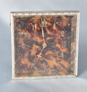Pequeño reloj cuadrangular sobre simil carey (833) 8 x 8 cm.