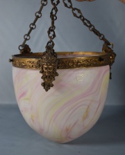 Colgante de vidrio rosado. Con tres cadenas y virola de bronce con mascarones. Alto: 20 cm.