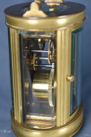 CARRIAGE CLOCK BLACK, caja de bronce dorado de sección oval, con manija superior.