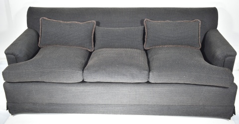 Sofá confortable de tres cuerpos, tapizado en tela labrada moteada gris oscura y marrón.