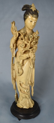 JOVEN MUJER CON RAMEADOS, figura de marfil finamente tallada. Base de madera circular deteriorada. Alto: 25 cm.