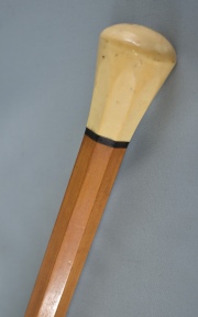 Baston, de madera clara facetada. pequeo pomo de marfil. Puntera de asta con desperfectos. 90 cm.