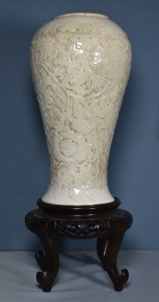 Vaso chino de cermica blanca con base de madera. Base con orificio de origen y cachaduras. Alto con base: 50,5 cm.