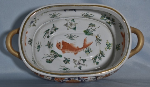 Centro chino, de porcelana oval con dos asas y decoracin de peces. Frente: 45 cm.