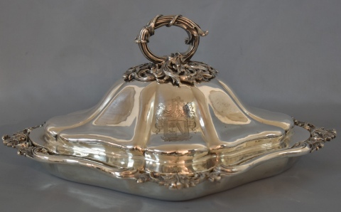 Legumbrera de plata Inglesa con escudo heráldico, apoya sobre rechaud de metal.