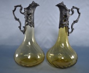 Dos garrafas para vino en vidrio, montura metal. 31 cm.