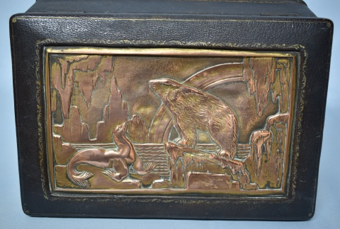 CAJA, de cuero con placa de bronce en la tapa, representando un paisaje polar con oso y foca. Mide: 23, 5 x 16 x 7, 5 cm
