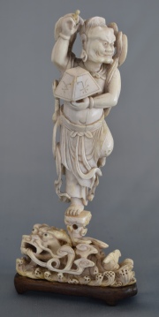 DEMONIO CHINO CON DRAGON, figura de marfil tallado y calado. Base de madera. Alto: 15, 5 cm.