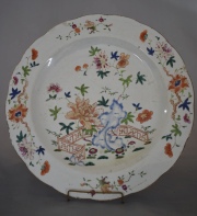 PLATO CHINO, de porcelana Famille Rose. Con decoración de flores y hojas polícromas. Borde con cachaduras. Diámetro: 39