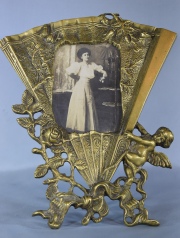 PORTA RETRATO, en forma de abanico de bronce dorado y ornado con ángel y flores. Alto: 27 cm.
