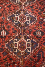 ALFOMBRA SHIRVAN, de lana. Profusa ornamentaci´n de motivos florales sobre fondo bordo en el centro y azul en el resto.