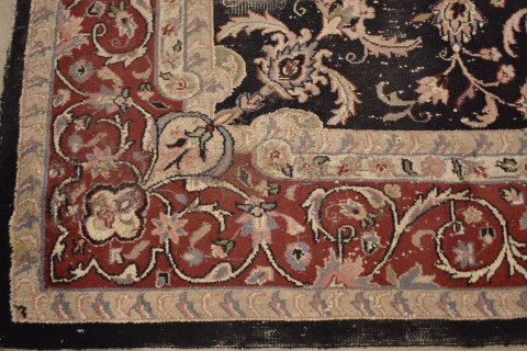 ALFOMBRA PERSA, de lana, de fondo negro con profusa ornamentación de motivos florales poliícromos estilizados. Desgastes