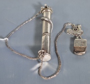 Yesquero, realizado en plata, cuerpo cilíndrico donde se enrosca una serpiente. Tapa y pedernal con figura de gallo. Ex