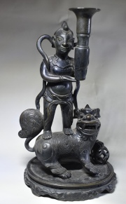 PORTA INCIENSO CHINO, de bronce patinado en forma de personaje parado sobre perro de fo. Alto: 28 cm.