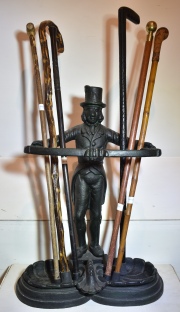PARAGUERO, de hierro fundido con figura de hombre con galera. Con seis bastones de diferentes modelos. Alto: 65 cm.