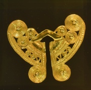 Nariguera, pieza de oro colombiana contenida en acrílico.