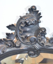 ESPEJO ITALIANO, de madera ebonizada y tallada con decoración de rocallas, hojas y molduras. Alto: 99 cm. Frente: 71 cm