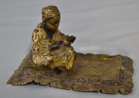 Franz Bergmann. Figura de Niño sobre alfombra. escultura en bronce. Frente: 14,3 cm. Alto: 8,8 cm.