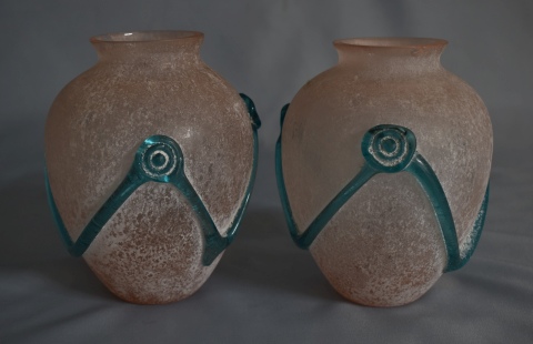 Par de vasos vidrio rosa con guarda verde, cachaduras. Alto: 15,5 cm.