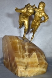 PATINADORES, escultura de bronce dorado sobre base de mármol veteado. Alto: 31 cm.