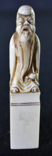 DIGNATARIO, figura china de marfil tallado. Debajo sello inciso con caracteres orientales. Alto: 11 cm.