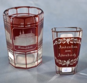 Dos vasos de bohemia, distintos, color rubí y neutro. Alto: 8,8 y 7 cm.