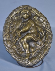 Niño, relieve en bronce oval. Alto 27 cm.