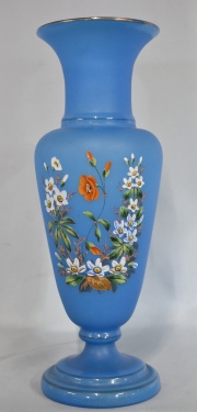 Vaso opalina turquesa con flores blanca y naranja. Cachadura de manufactura en la base. Alto: 41 cm.