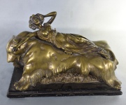 Figura de mujer elevable, sobre oso, de bronce dorado. Frente: 20 cm. Alto: 13 cm.