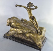 Figura de mujer elevable, sobre oso, de bronce dorado. Frente: 20 cm. Alto: 13 cm.