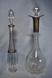 Dos botellones de cristal, uno de Baccarat, con tapones. Alto: 36 y 38 cm
