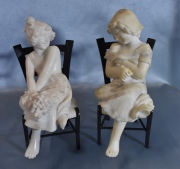 Niñas con uvas, dos esculturas pequeñas de alabastro sentadas en sillas de bronce. Dedo faltante. un pie con roturas. Al